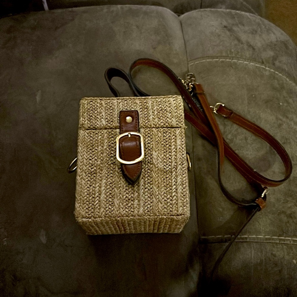 A purse that’s tan and brown with gold accents